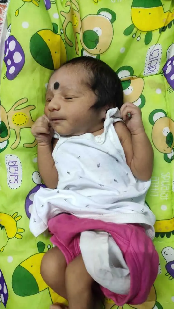 Infant, born after ICSI treatment at Karthika Datta's IVF in 2021, pictured sleeping peacefully, on a colorful baby bed.